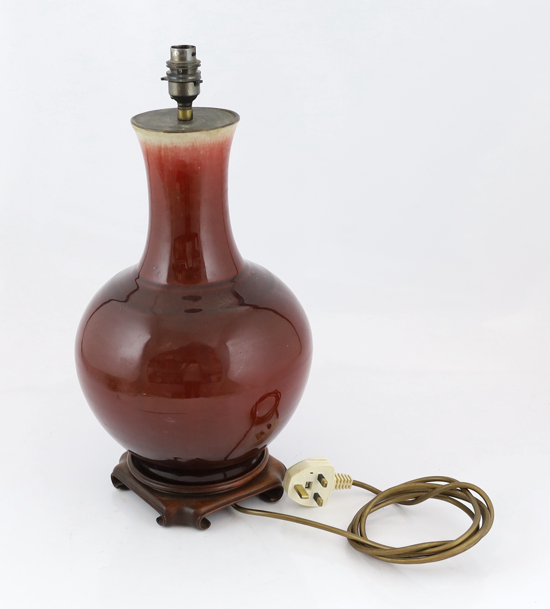 A Chinese sang de boeuf glazed vase, 19th century, the crackle glaze graduating from mushroom grey to copper red, later drilled and mounted as a lamp, height including wood stand 40.5cm, restored rim